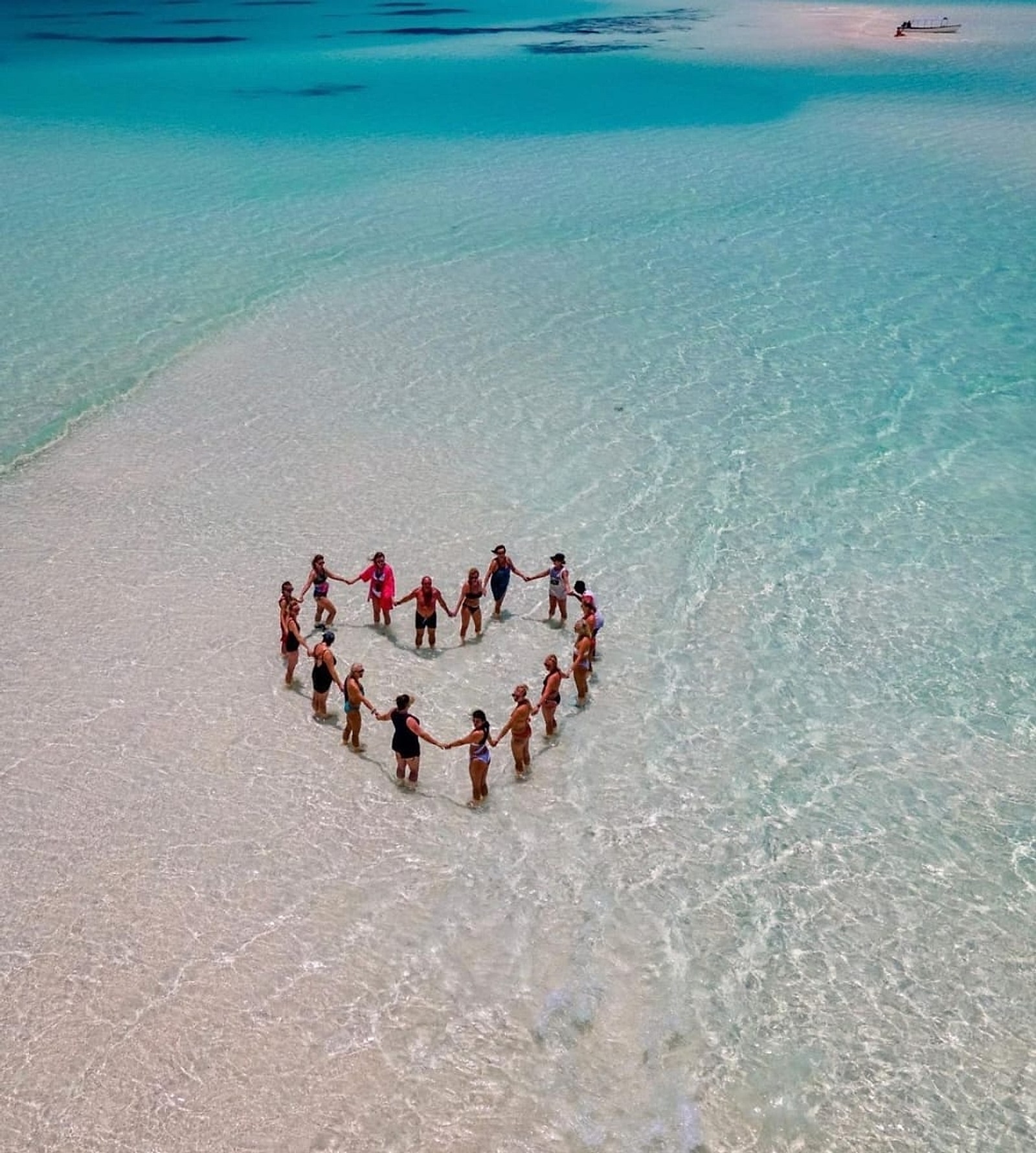 Travellers forming a heart on a Zanzibar sandbank