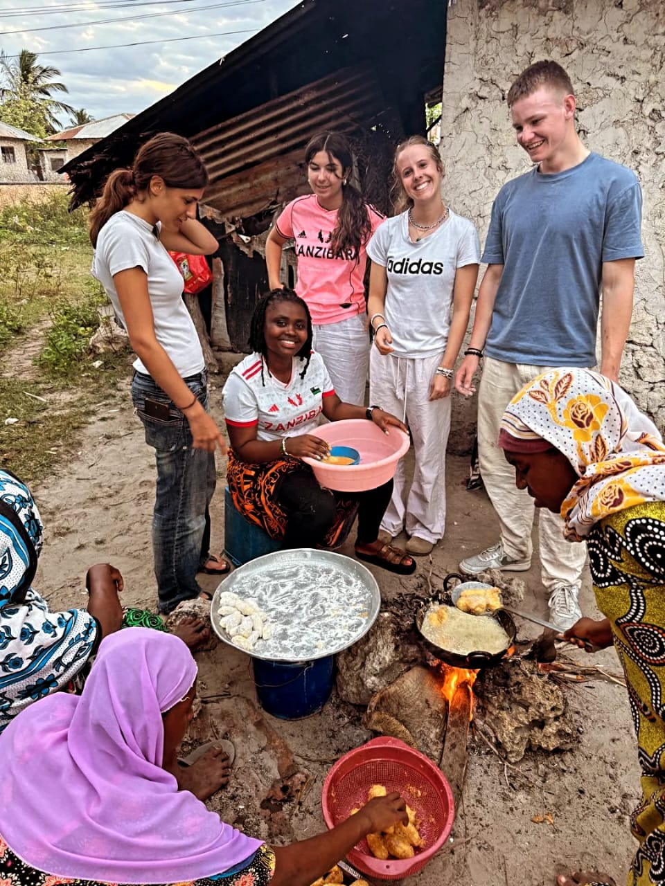 Travellers cooking traditional food over a fire in Zanzibar