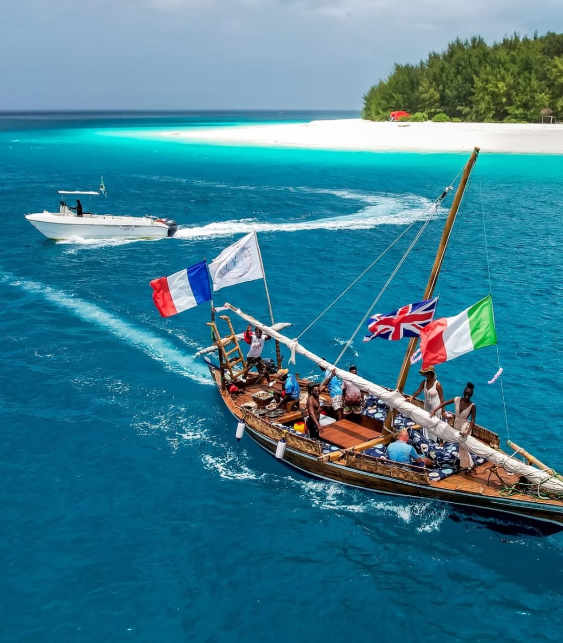 A traditional dhow crossing turquoise water beside Zanzibar