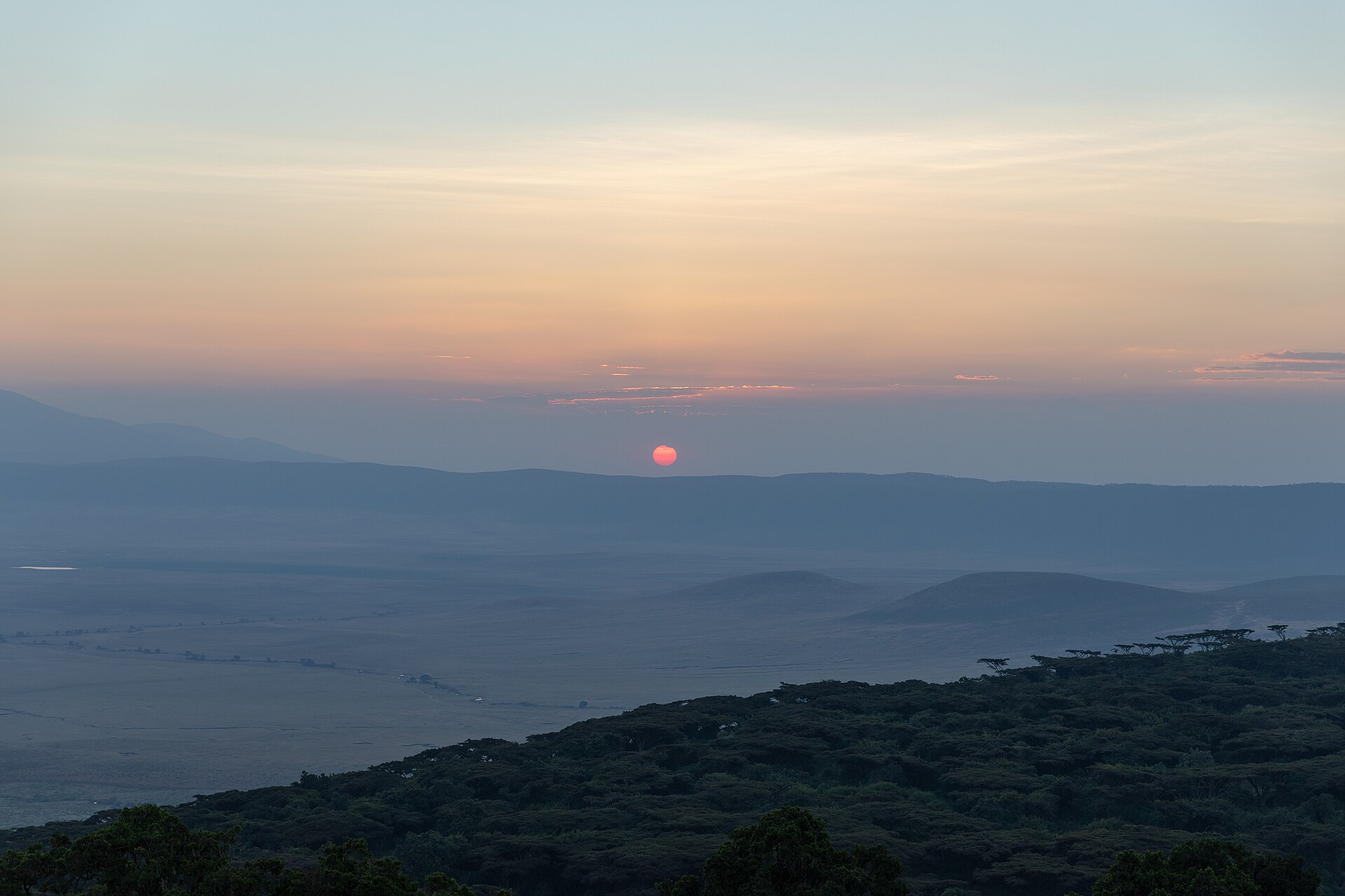A low red sun above a distant ridge